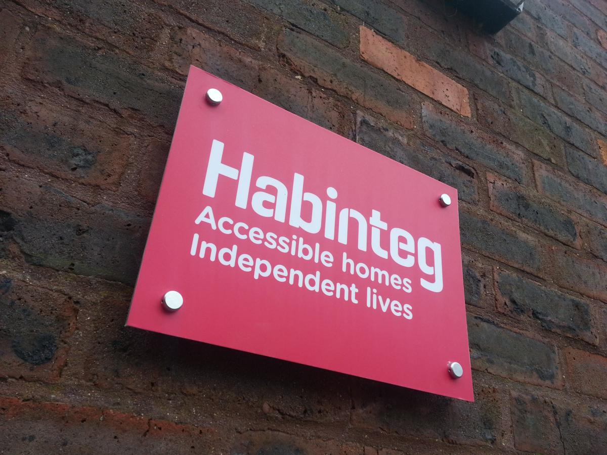 Habinteg sign/logo on a rick Wall